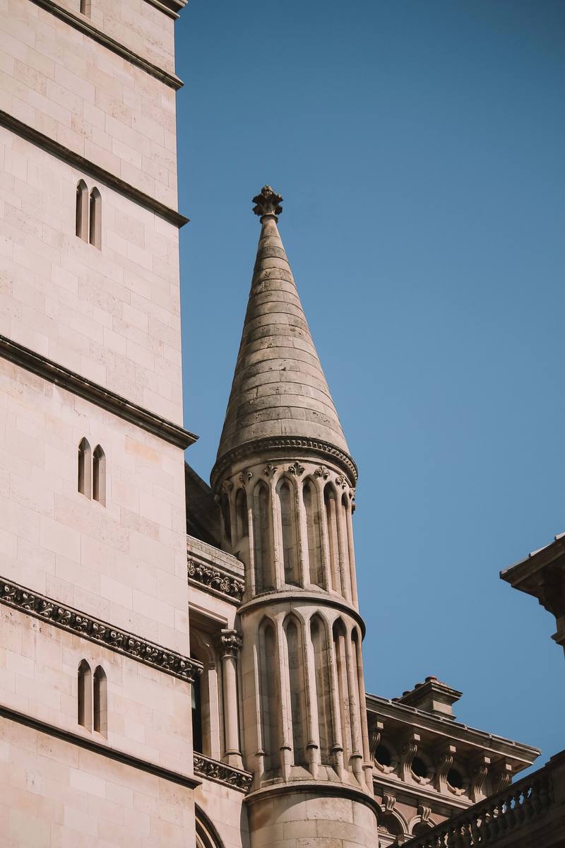A stone turret of the Royal Courts of Justice against a clear sky